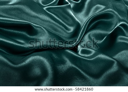 Background of emerald green fabric making curves