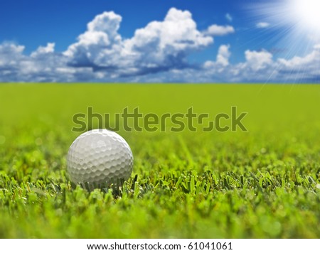 Golf ball on a golf course with sky and sun