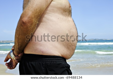 stock photo a Fat man on the beach