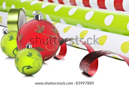 Rolls of gift wrapping paper and  ribbon  with red and green christmas baubles