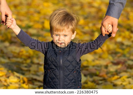Beautiful little boy walks in autumn park with mom and dad. Happy family concept