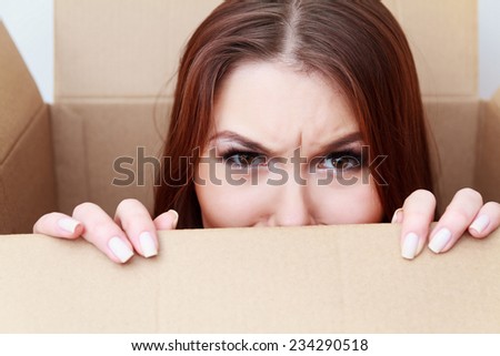 Beautiful girl inside a cardboard box. Difficult crossing concept. Emotions concept. Anger. Unexpected gift concept