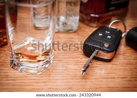 Car key on the bar with spilled alcohol and empty bottles. Booze driving concept. Drunk driver concept
