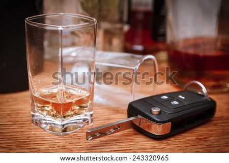 Car key on the bar with spilled alcohol and empty bottles. Booze driving concept. Drunk driver concept