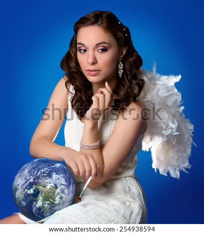 Thoughtful girl angel clears the planet from pollution. Ecological concept. Elements of this image furnished by NASA