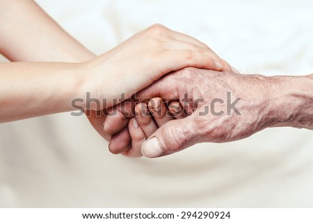 Hands of the old man and a young woman. close up. toning