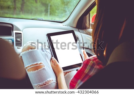 Girl with tablet in her hands in the car. Hitchhiking, car ride concept