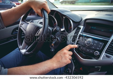 Car dashboard. Radio closeup. Man sets radio