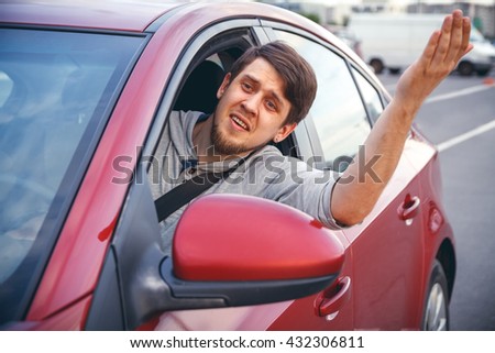 The young man driving the car angry, stuck in a traffic jam