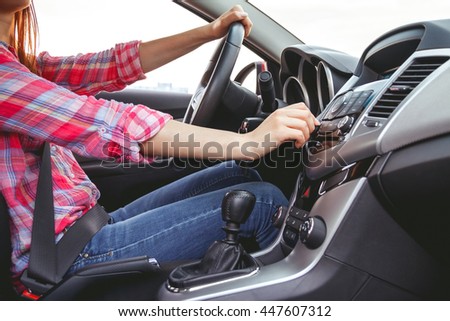 Car dashboard. Radio closeup. Woman sets up radio