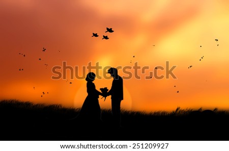 Silhouette human in love up over blurred on sunset nature background.
