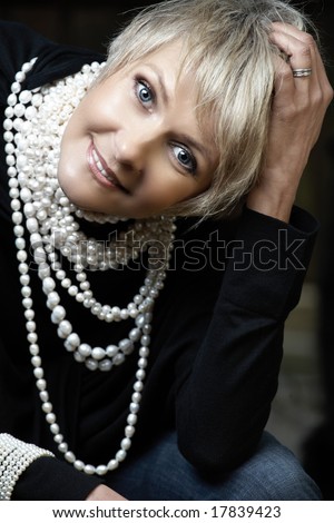 beautiful happy woman in her mid 40s with blond short hair wearing fresh water pearls