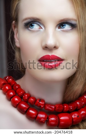 Beautiful blond woman wearing red corals and red lipstick
