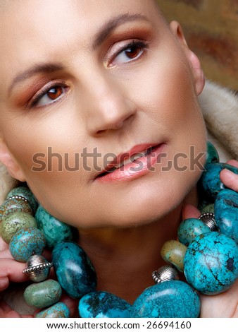 Portrait of beautiful happy bald woman with turquoise necklace