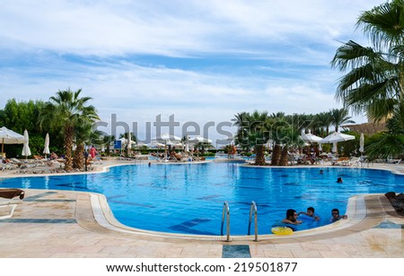 TABA, EGYPT - NOVEMBER 22, 2013: Unidentified people relax by the pool of hotel Intercontinental Taba Heights Resort in November 22, 2013 in Taba, Egypt