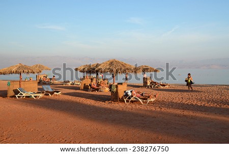 TABA, EGYPT - NOVEMBER 22, 2013: Unknown people are resting on the beach in Egypt in November