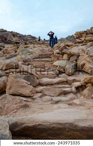 SINAI MOUNTAINS, EGYPT - NOVEMBER 28, 2013: Unidentified people descend along the stairs from the cobblestones from the top of Mount Moses, Egypt