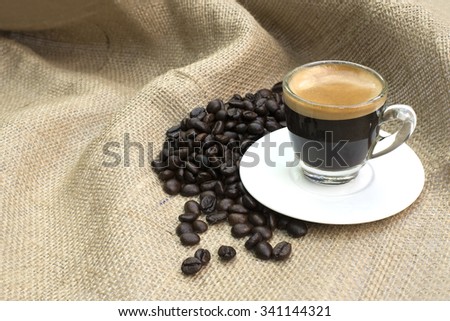 Shot of Espresso with beans on fabric