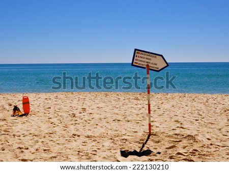 Beach in Faro with sign and the words guarded beach, Portugal.