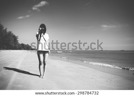 A single girl take a picture at the beach (black and white)