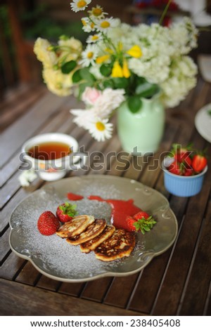 composition of pancakes, flowers and tea