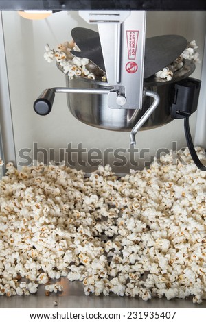 A popcorn machine in the middle of popping