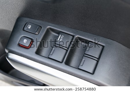 car interior details of door handle with windows controls and adjustments. Car window controls
