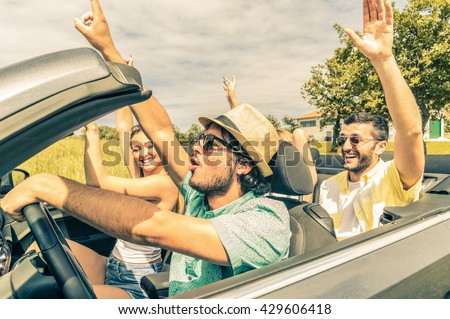 Group of friends having fun at car trip around Europe. Friends at vacations driving on the road