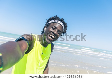 Sportive black man taking selfie at the beach
