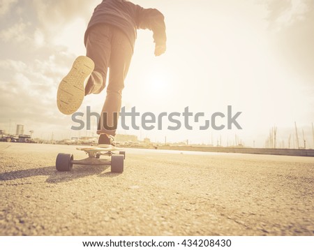 Young man riding on a skate in the city street. Vintage style.