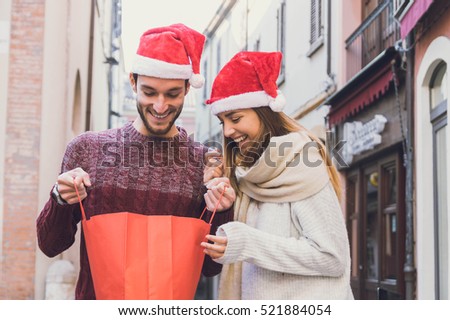 Picture showing young couple doing Christmas shopping in the city