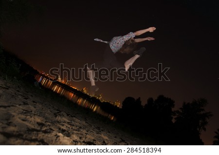 Young girl jumping on the beach pulls hands to the sky