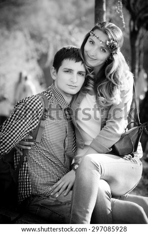beautiful girl sitting at the guy on his knees. black and white photo