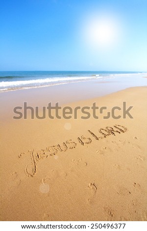 Beautiful beach with sand, blue waves, sky and text Jesus is Lord