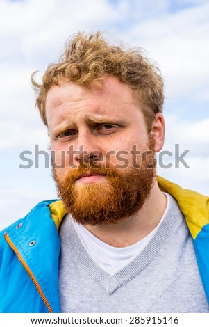 Young red bearded hipster looking into camera