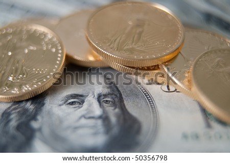 Gold bullion and one hundred dollar note. Very shallow DOF to focus on  Benjamin Franklin eye