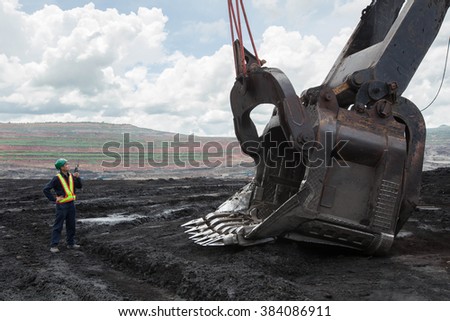 Coal trucks and loaders are hauling the coal away to to a power plant simultaneously.