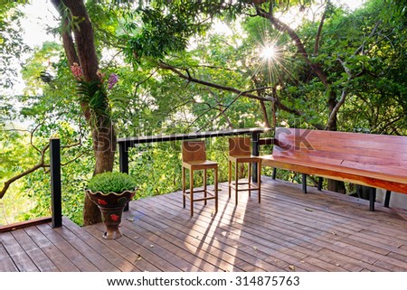 Wooden deck with benches and chair in the backyard
