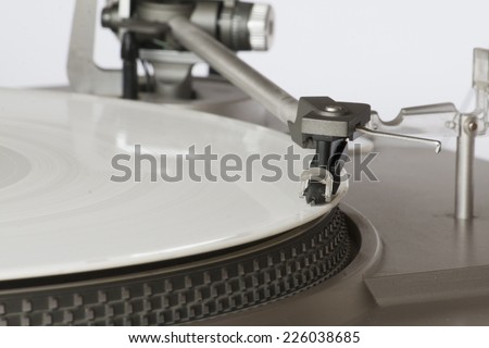 Vintage record player playing a white vinyl record