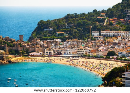 Panorama of the beach with swimming and sunbathing people (coast of Catalonia, Tossa de Mar City)