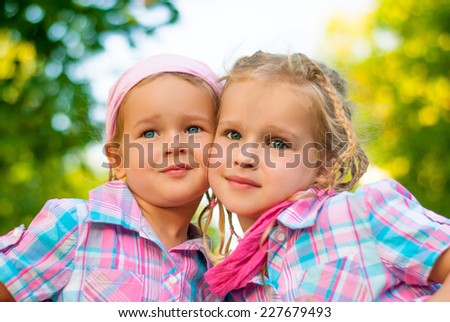 Two little beautiful sisters hugging and smiling