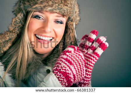 Portrait of beautiful blond woman in warm clothes on blue background