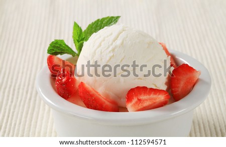 Small dish of custard with ice cream and fresh strawberries