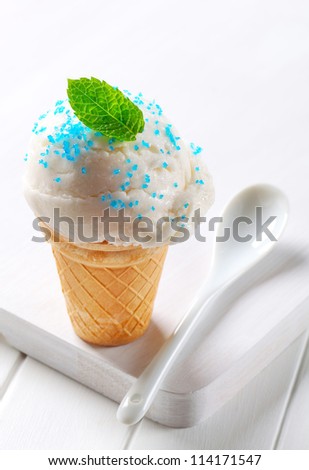 Lemon ice cream cone topped with sprinkles