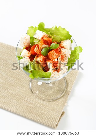 Feta cheese with lettuce and tomato in a glass cup