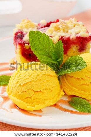 Cherry sponge cake with two scoops of apricot ice cream on a plate
