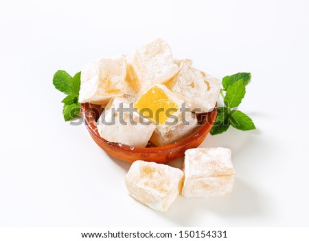 Tasty pieces of orange turkish delight in a ceramic bowl