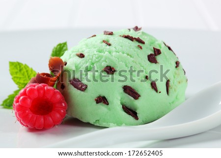 Scoops of pistachio ice cream with raspberry and chocolate curls