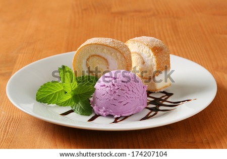 Slices of sweet cream roll with a scoop of blueberry ice cream