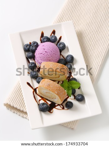 Slices of sweet cream roll with blueberry ice cream and fresh fruits
